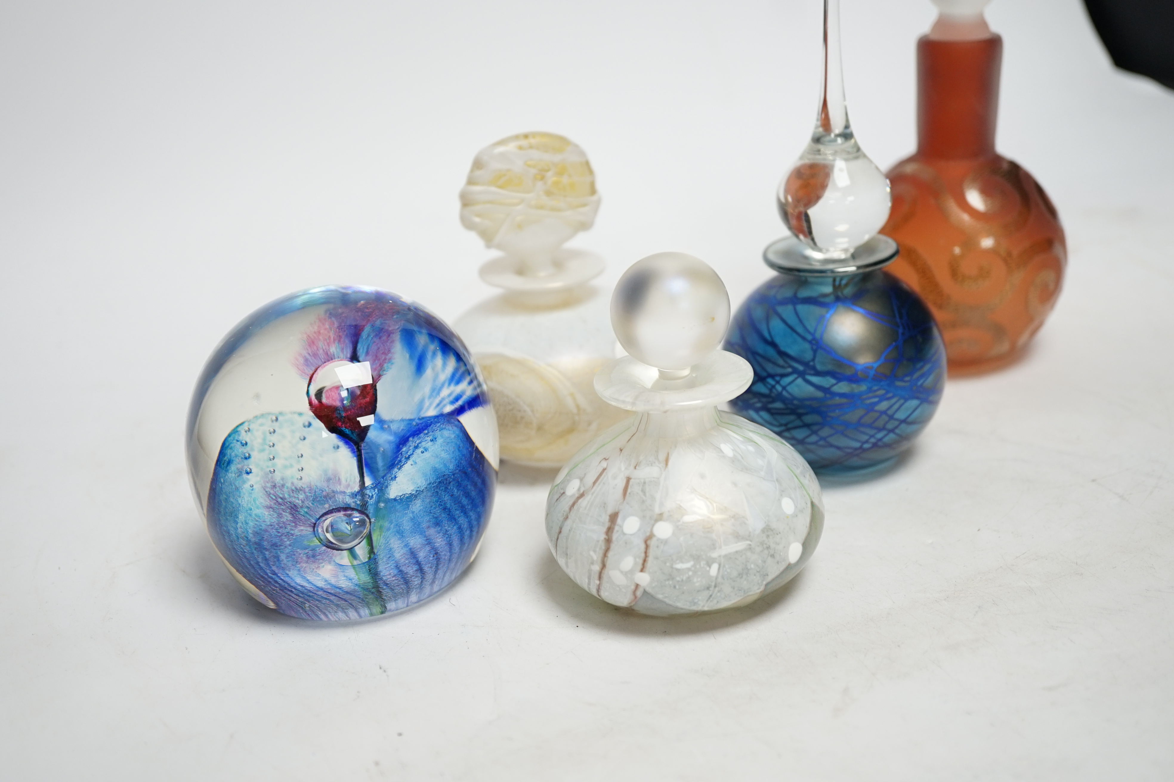 Four perfume bottles possibly by Blow Zone and paperweight by Helen Millard, tallest 17cm high